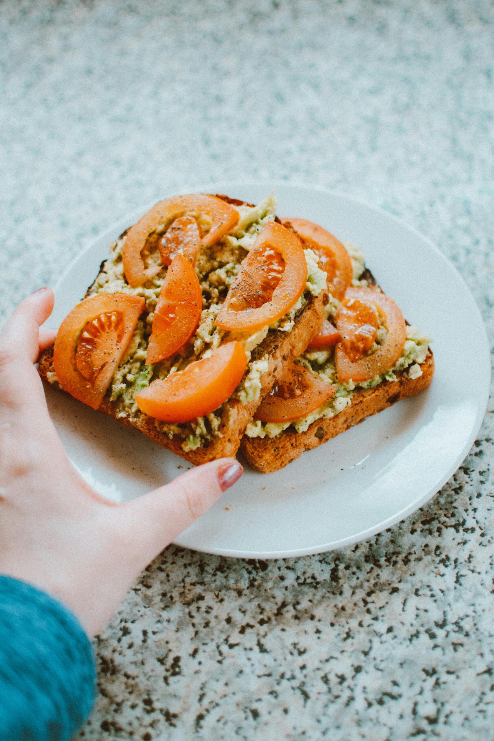 Close-up of delicious homemade avocado tomato toast on a plate.