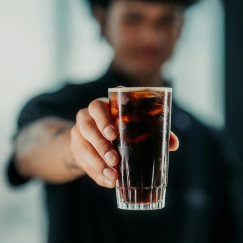 A bartender offers a chilled glass of fernet with ice, capturing a classic Buenos Aires nightlife moment.